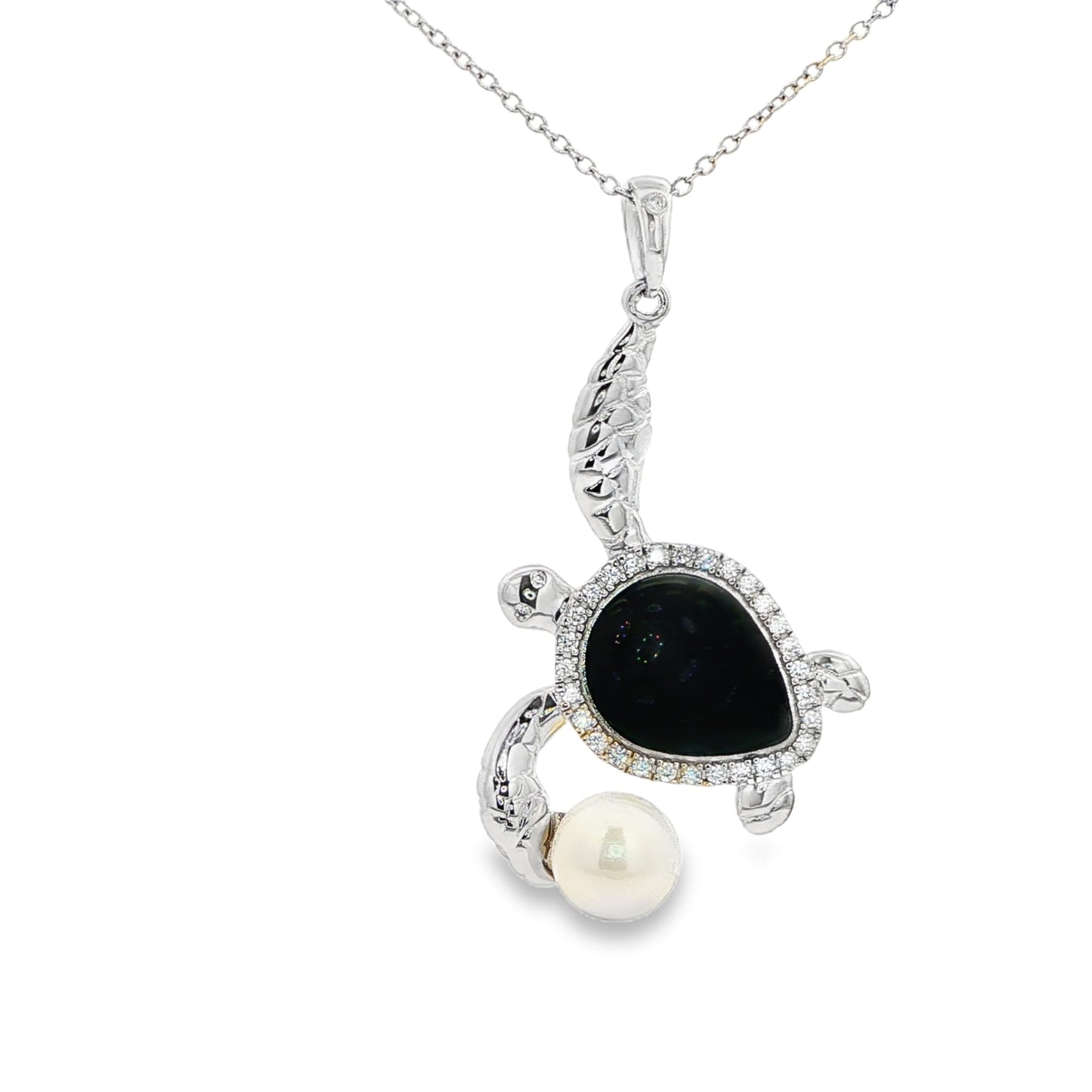 Sterling silver sea turtle with black body, white stones, and faux pearl adornment